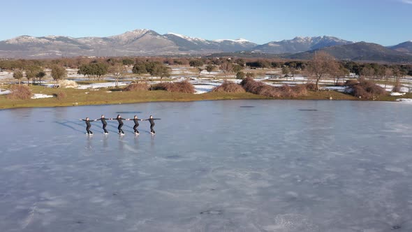 Group of young women firgure skating in a row on frozen lake