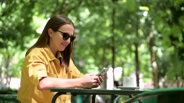 Side View at Smiling Young Woman Using Smartphone Outdoors Texting Online