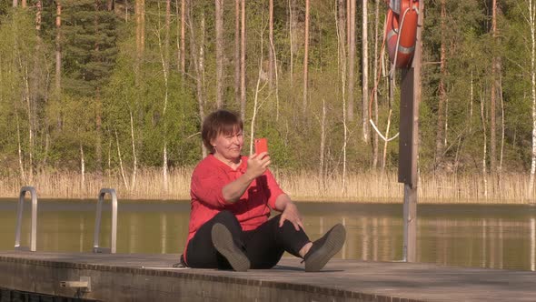 Closer Shot of a Middle Aged Lady Taking Selfies on a Floating Swimming Bridge