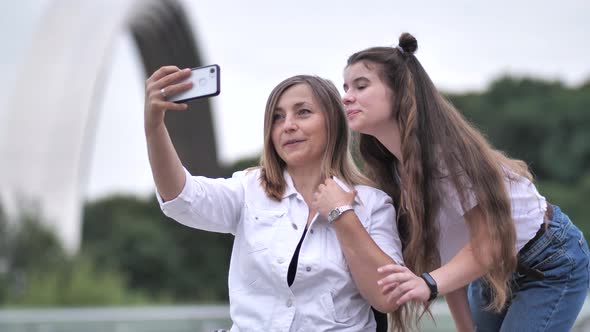 Happy Girl and Disabled Mom Taking Selfie Outdoors alt