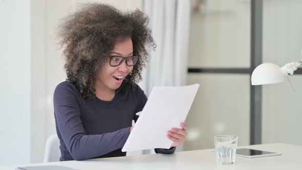 Successful African Woman Excited While Reading Documents alt