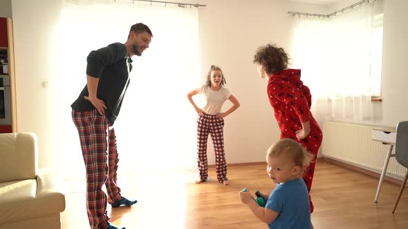 Father and Children Are Doing Exercises in Pajamas alt