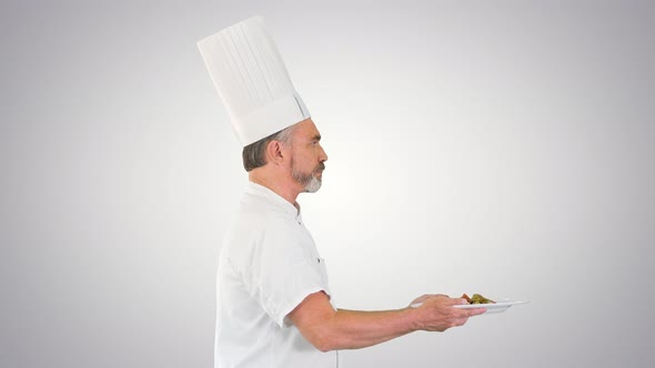 Male Chef White Uniform Running with a Plate of Salad on Gradient Background alt