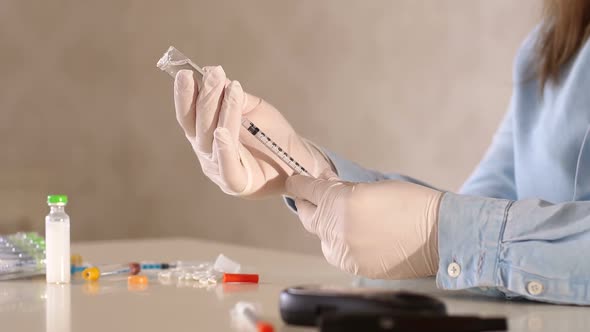 A Girl in Gloves is Picking Up Shortacting Insulin in an Insulin Syringe alt