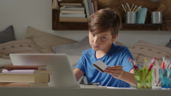 online shopping with credit card, student boy uses a computer at home