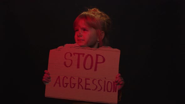 Afraid Dirty Faced Homeless Poor Girl Showing Banner with Inscription Massage Stop Aggression alt