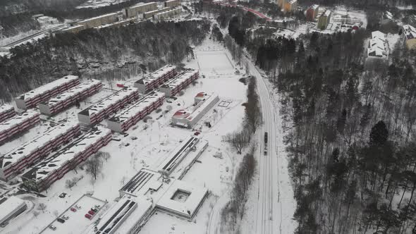 Trolley Train Traveling Through Suburb During Winter Tracking Aerial