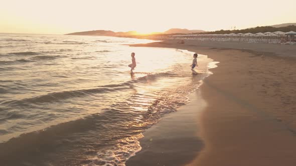 Young Sister and Brother Who Are Playing in the Sea