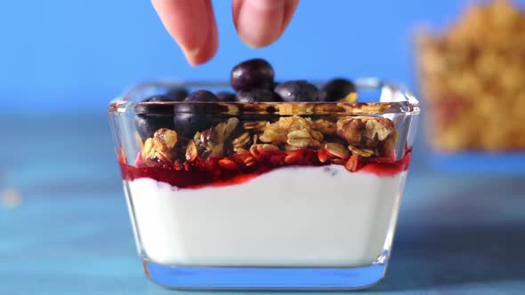 Adding blueberry to yogurt, granola and berry jam alt