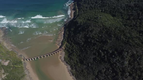 Birds eye drone shot of Wilderness beach in South Africa - drone is circling around the old railway alt