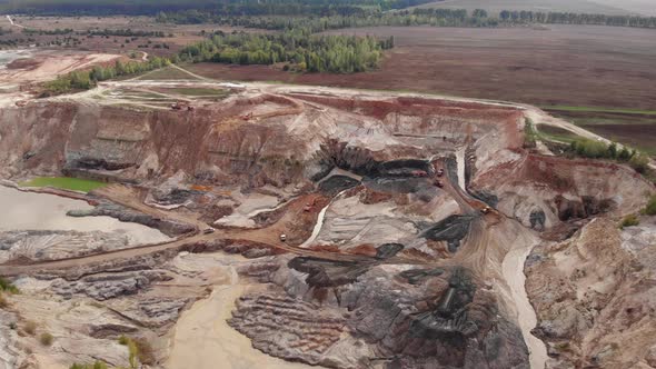 Industrial of opencast mining quarry with lots of excavators and trucks at work. alt