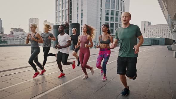 Running Club Group of Likeminded People Run Early in the Morning at Dawn Along the Urban Streets alt