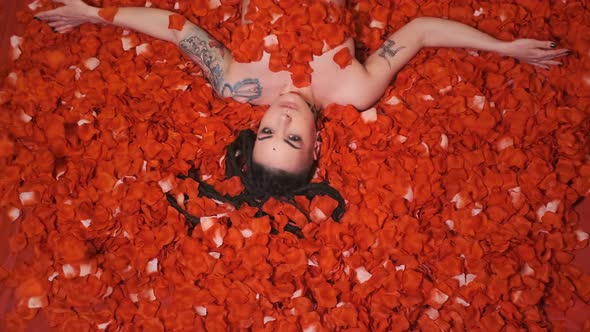 Beautiful Girl lies in petals red roses