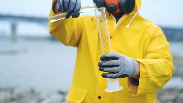 Modern environmental protection. ecologist pours water from river into test tube alt