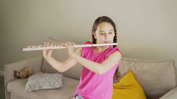 Teenage Girl Musician Plays Flute at Home