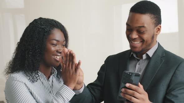Happy Confident Smart Young Multiethnic Colleagues Looking at Cellphone Check Social Media alt