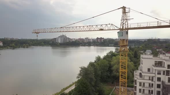 Aerial view of tower crane and residential building under construction. alt