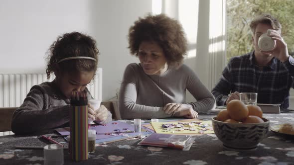 Parents with daughter drawing in living room