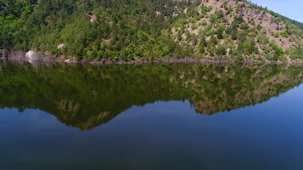 Forest and mountain reflected in the lake. alt