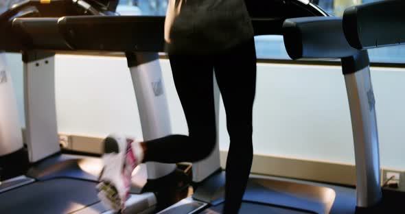 Rear view of fit woman exercising on treadmill alt