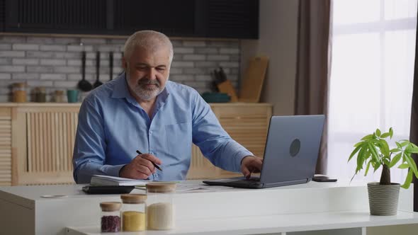 Male Accountant is Working From Home at Weekend Overtime Work and Reporting Period Using Laptop and alt