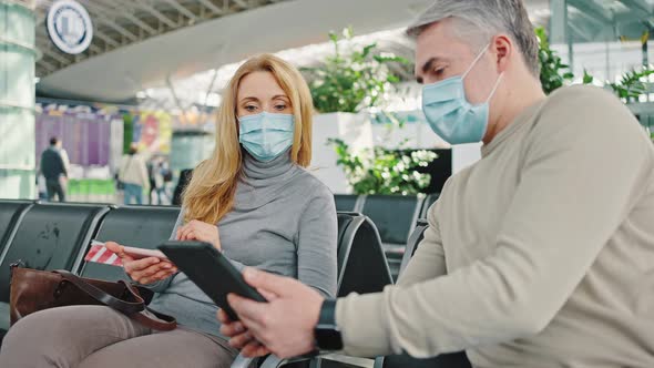 Mature Man Having Problems with Digital Tablet Asking for Help Woman Sitting Nearby Waiting for alt