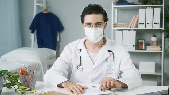 Doctor Working at Hospital Closeup Young Surgeon Sitting at Workplace Male Therapist Wearing Medical alt