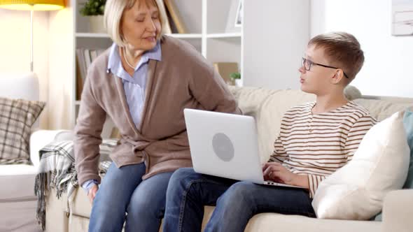 Retired Woman Watching Her Grandson Using PC alt
