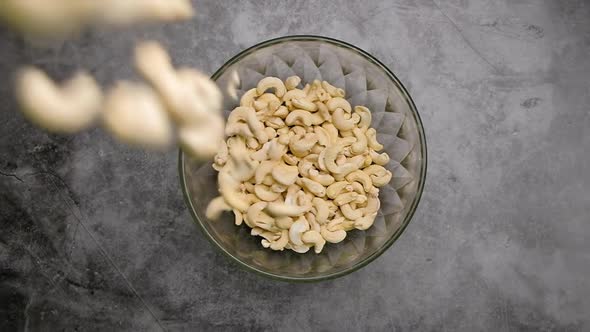 Top view falling cashew nuts into a bowl, Slow motion.