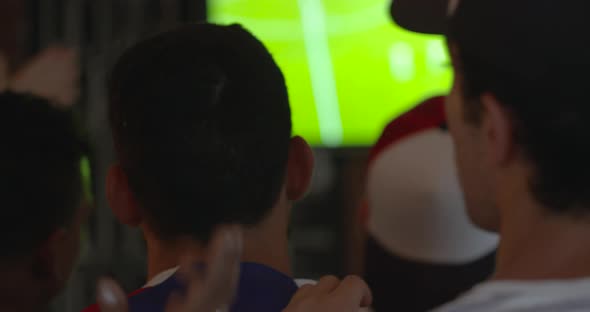 Sports fans watching televised match in sports bar, slow motion