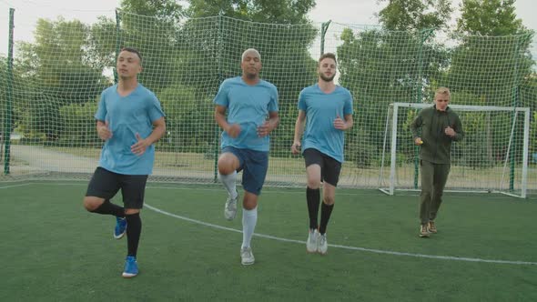 Front View of Soccer Players Performing High Knee Running Outdoors alt