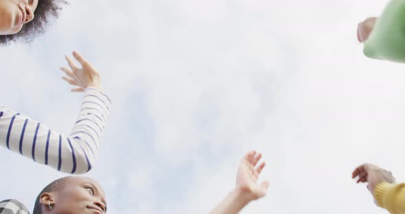 Diverse male and female business colleagues stacking hand and motivating in office alt