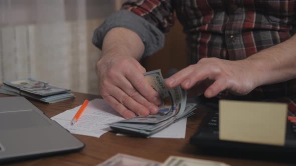 An Elderly Man Keeps a Record of His Cash