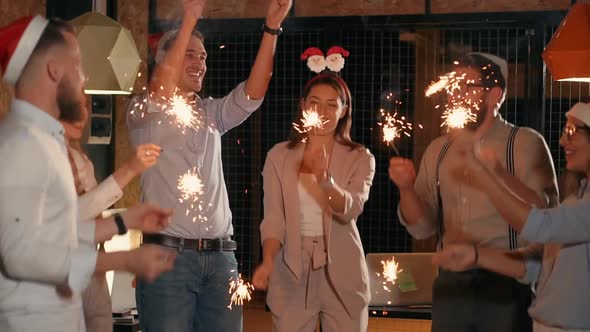 Office Employees Are Celebrating Christmas in Working Place Burning Sparkles alt