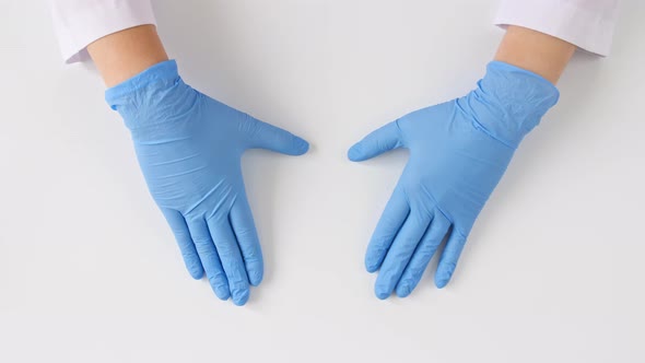 Doctor's Hands in Medical Gloves Shows the Symbol of the Heart on White Background with Copy Space alt
