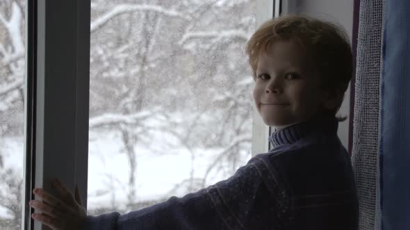 Boy And Snow Outside The Window