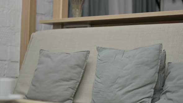 Young Woman Coming in and Opening Laptop on Sofa alt