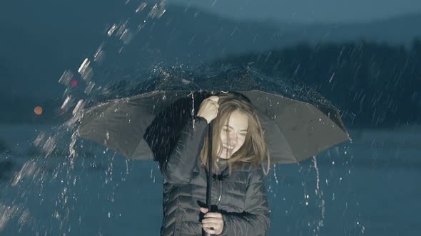 Excited Girl Enjoys Heavy Rain By River at Night Slow Motion alt