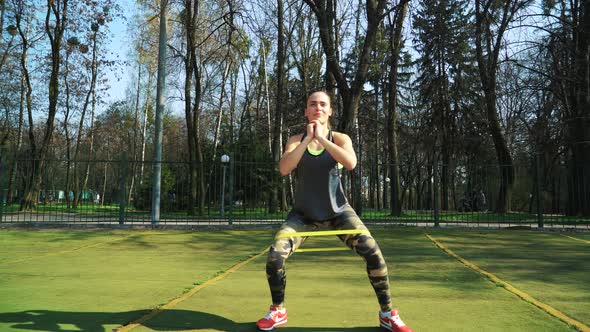 Woman doing exercises outdoors at the stadium alt