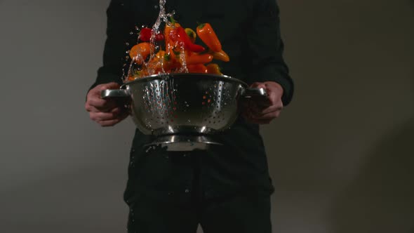 Chef with colander full of peppers splashing in super slow motion, shot with Phantom Flex 4K