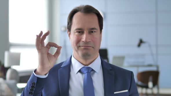 Okay Sign By Satisfied Businessman alt