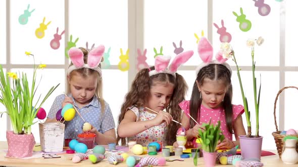 Happy Children Wearing Bunny Ears Painting Eggs on Easter Day