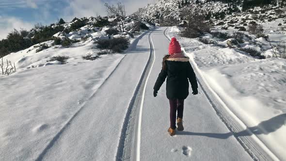 Small Girl Walking On Snow Covered Road Slow Motion 