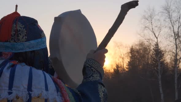 Slow Motion of the Shaman Beats the Tambourine at Sunset.