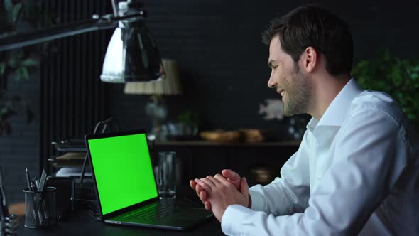 Positive Businessman Video Chatting Online on Laptop with Green Screen in Office alt