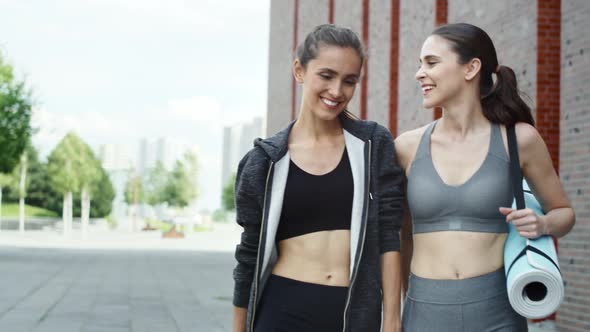 Video of two women walking and talking in training clothes. Shot with RED helium camera in 8K. alt