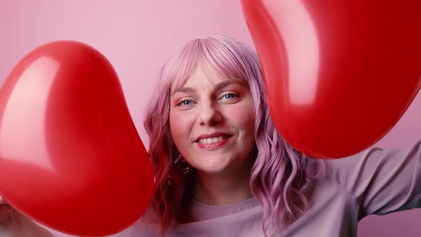 Happy Beautiful Woman in Good Mood Smiling Holding Red Balloon Shaped Heart Celebrates Valentine's