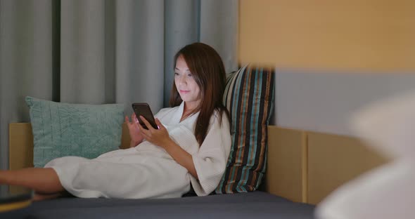 Woman Look at Mobile Phone and Sit on Sofa at Night