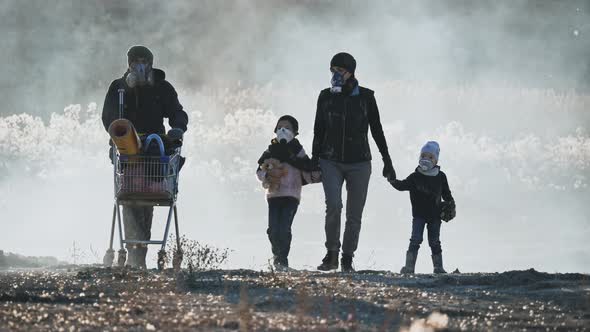 Survivor Family in Gas Mask Going Through Clouds of Toxic Smoke in Desolate and Burned Landscape. alt