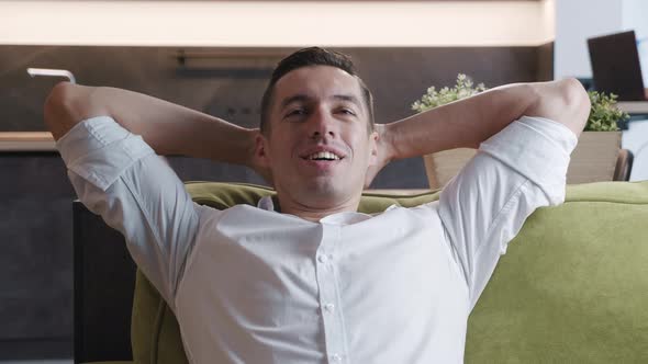 Calm Relaxed Young Man Resting on Cozy Sofa at Home. Happy Businessman Breathing Fresh Air Lounge on alt